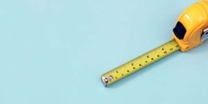 The yellow measuring tape for the mason is placed on a blue background. Soft focus.