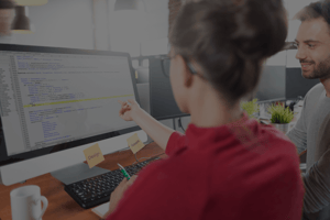 Two people working on computer and talking