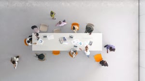 People working around a boardroom table with a view from above