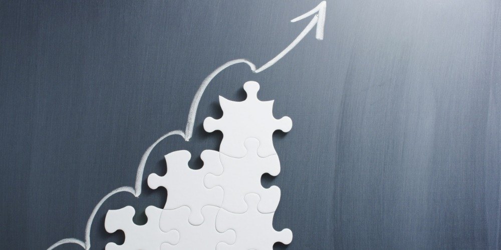 Concept image of making growth strategy. Connected puzzle pieces forming an upward slope. Line moving above puzzle pieces to show growth.